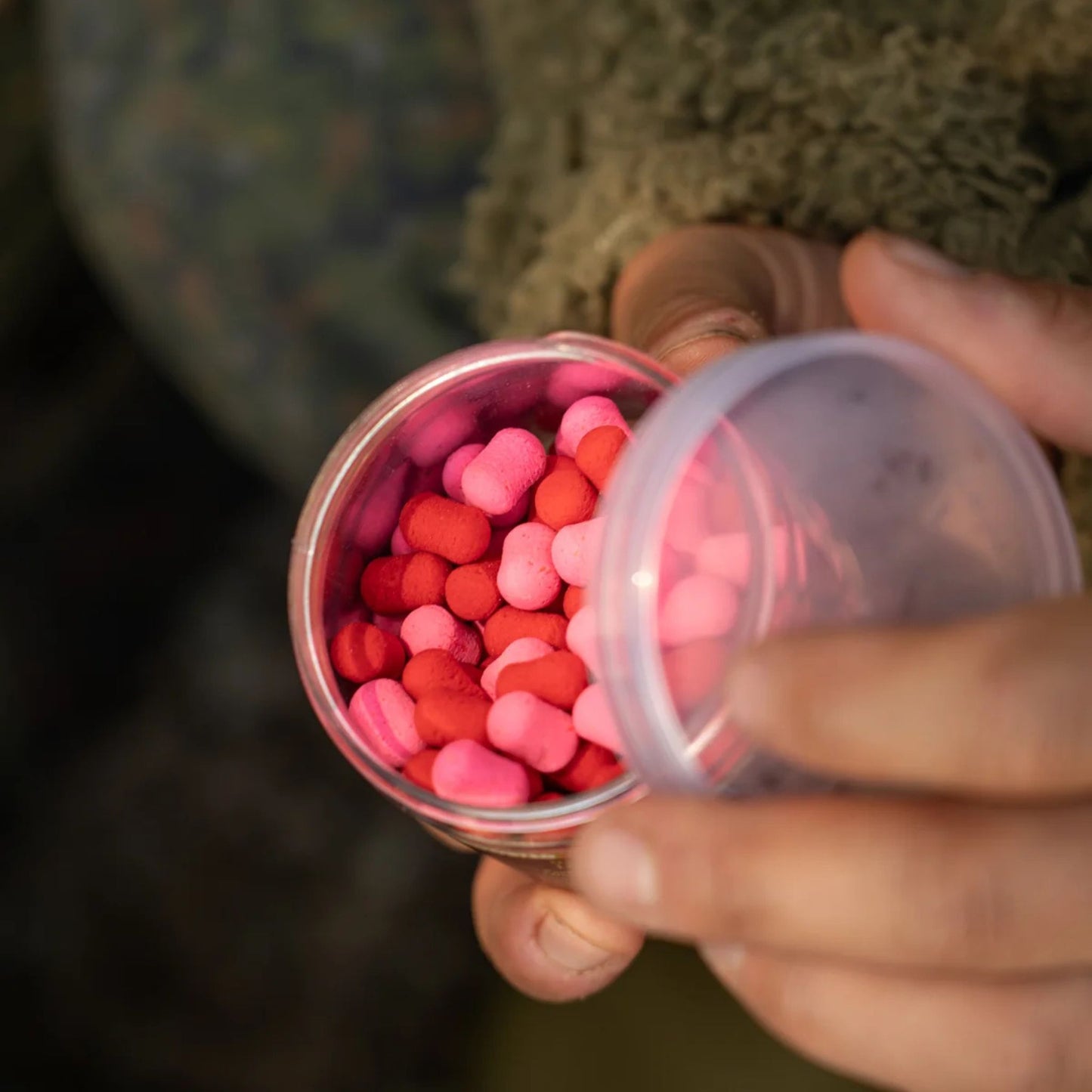 OMC Paella Boosted Fluoro Wafters Pink Red open 200 ml tub in angler's hands showing hookbaits