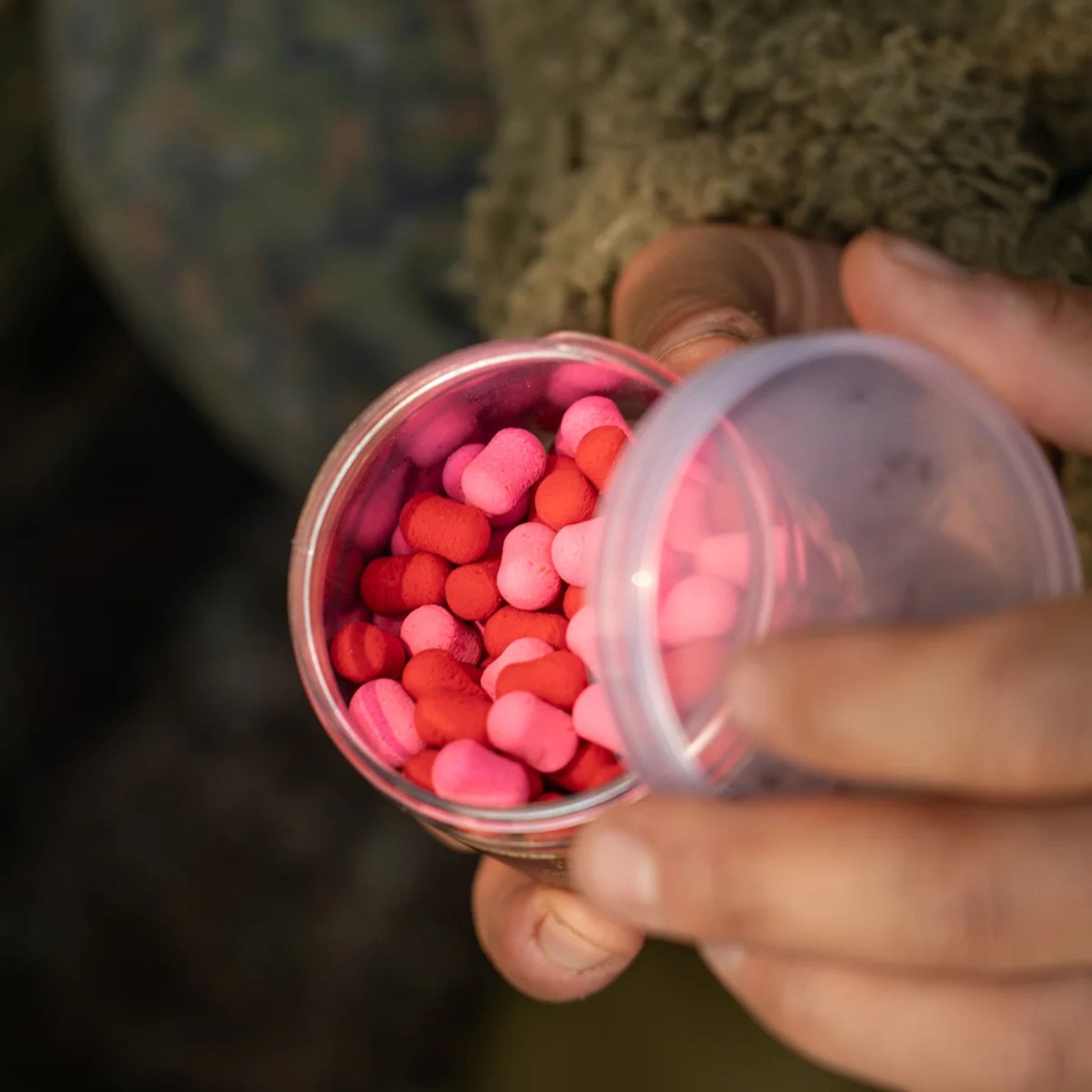 OMC Paella Boosted Fluoro Wafters Pink Red open 200 ml tub in angler's hands showing hookbaits
