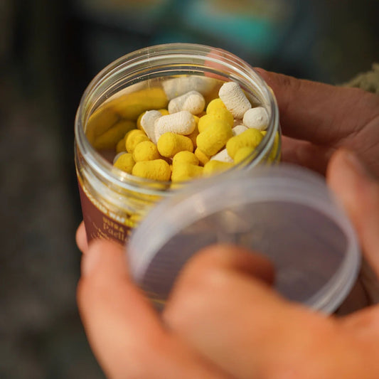 OMC Paella Boosted Fluoro Wafters White Yellow open 200 ml tub in angler's hands showing hookbaits