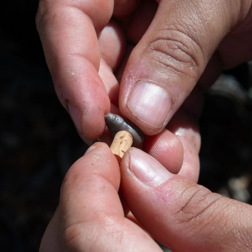 OMC Revibed Escargo - angler's hands showing cork cylinder being inserted into hollow snail body cavity for improved buoyancy